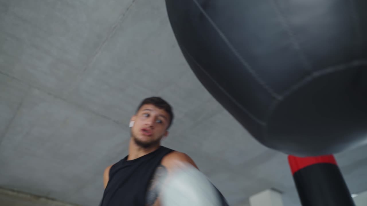 낮은 각도 뷰 남성 권투 선수 권투 가방으로 공격적으로 훈련