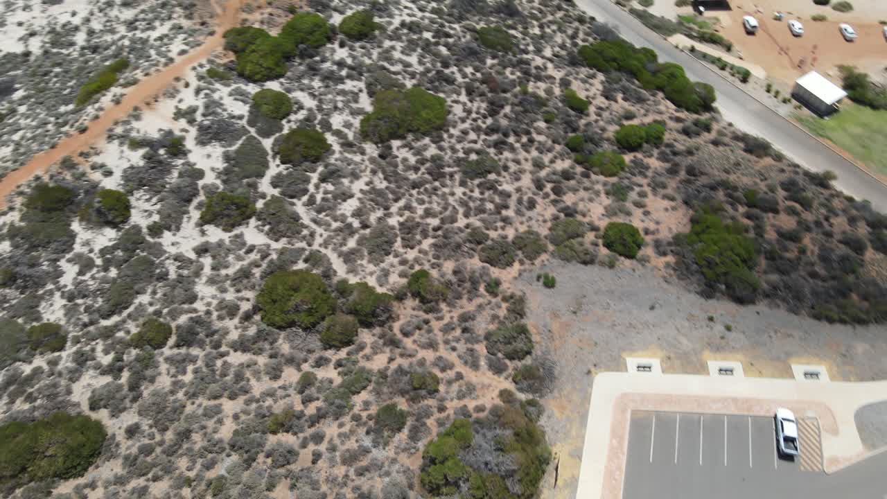 drone girando en el aire y subiendo de una caravana y estacionamiento a una hermosa playa