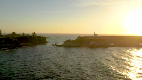 drone flying over ocean at sunset towards cape arago lighthouse at the oregon coast near coos bay and charleston