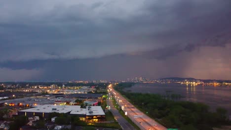 Vista-Aérea-A-Gran-Altitud-Desde-Una-Tormenta-Que-Se-Avecina-Sobre-La-Vía-Pública-En-Montreal,-Canadá