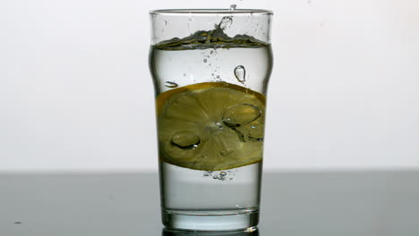 lemon slice falling into pint of water