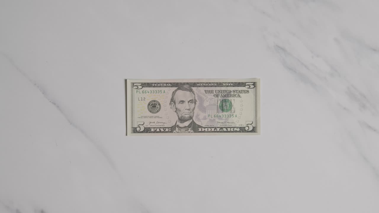 마블 표면 1에 5 달러 지폐를 잡는 손의 오버헤드 통화  ⁇