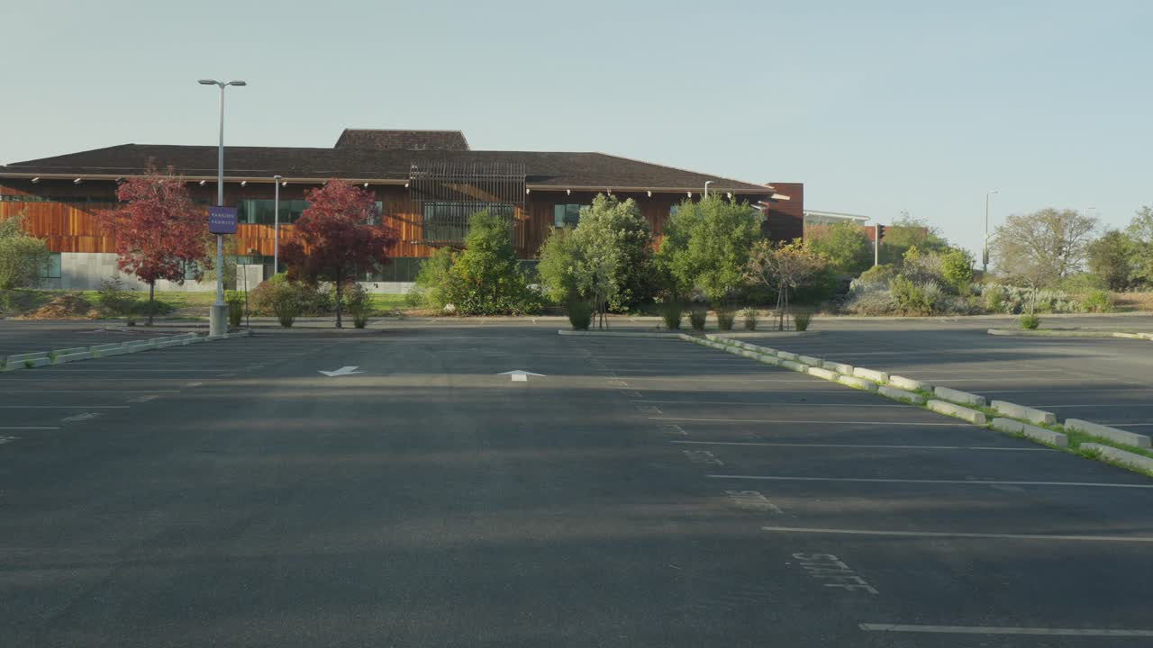 The camera moves forward toward Foothill College architecture, emphasizing clean lines, open walkways, and landscaped grounds set against the quiet slopes of Los Altos Hills