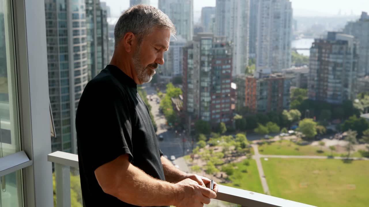 hombre usando teléfono móvil en balcón 4k