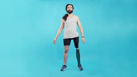 man with prosthetic leg standing with arms crossed against a blue background