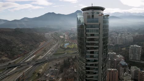 órbita aérea de un edificio en santiago de chile con vista panorámica a las montañas de la ciudad