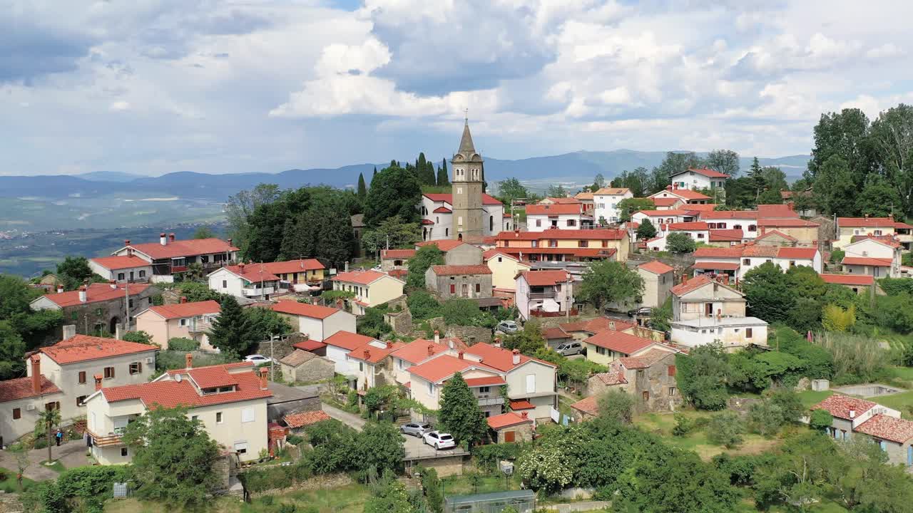 Rising aerial view of church and cityscape of small village, Pomjan, Slovenia