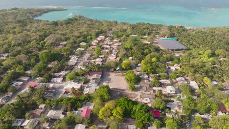 Drone view of Orika village on Isla Grande, Rosario Islands, Colombia. Traditional houses by the turquoise Caribbean Sea surrounded by lush tropical nature