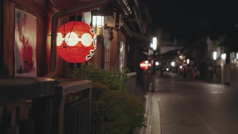 a dimly lit alley in kyoto at night, lined with traditional buildings and red glowing lanterns, creates a moody and atmospheric scene in the historic city.