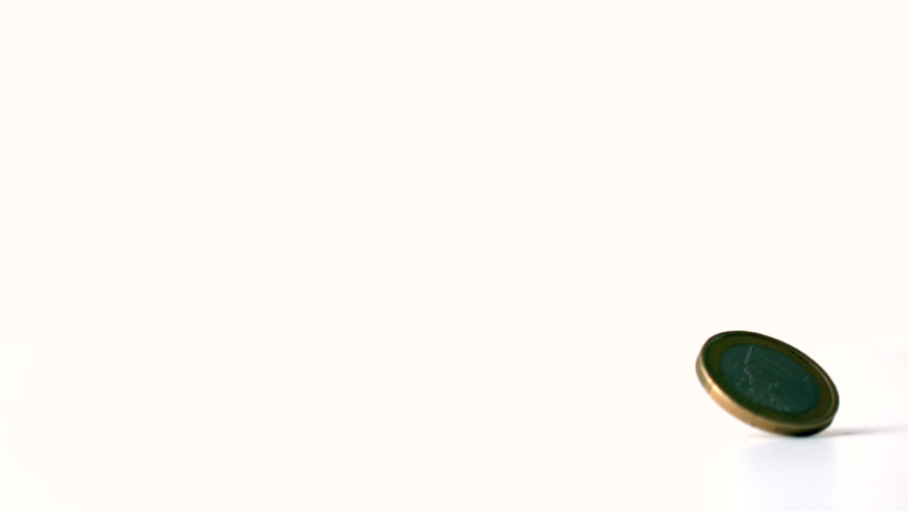 moneda de euro que gira sobre una superficie blanca