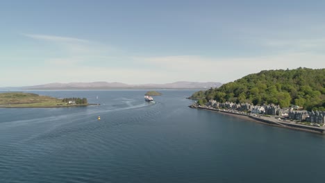 Toma-Aérea-Que-Revela-La-Entrada-Al-Mar-De-Oban-Con-El-Ferry-Que-Sale-Hacia-Mull.