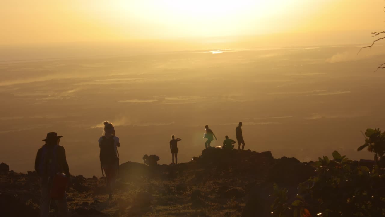 Silhouetted Hikers Witnessing a Breathtaking Sunset from a Mountaintop