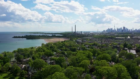 flying over the coast of lake ontario on a summer day with a beach and the toronto skyline in the background