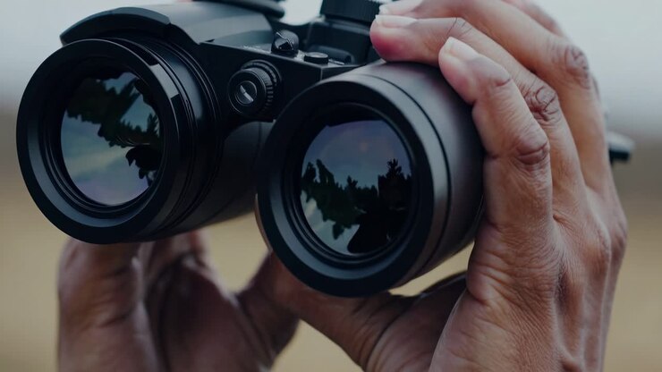 Close-up video of hands holding binoculars, capturing a sense of exploration