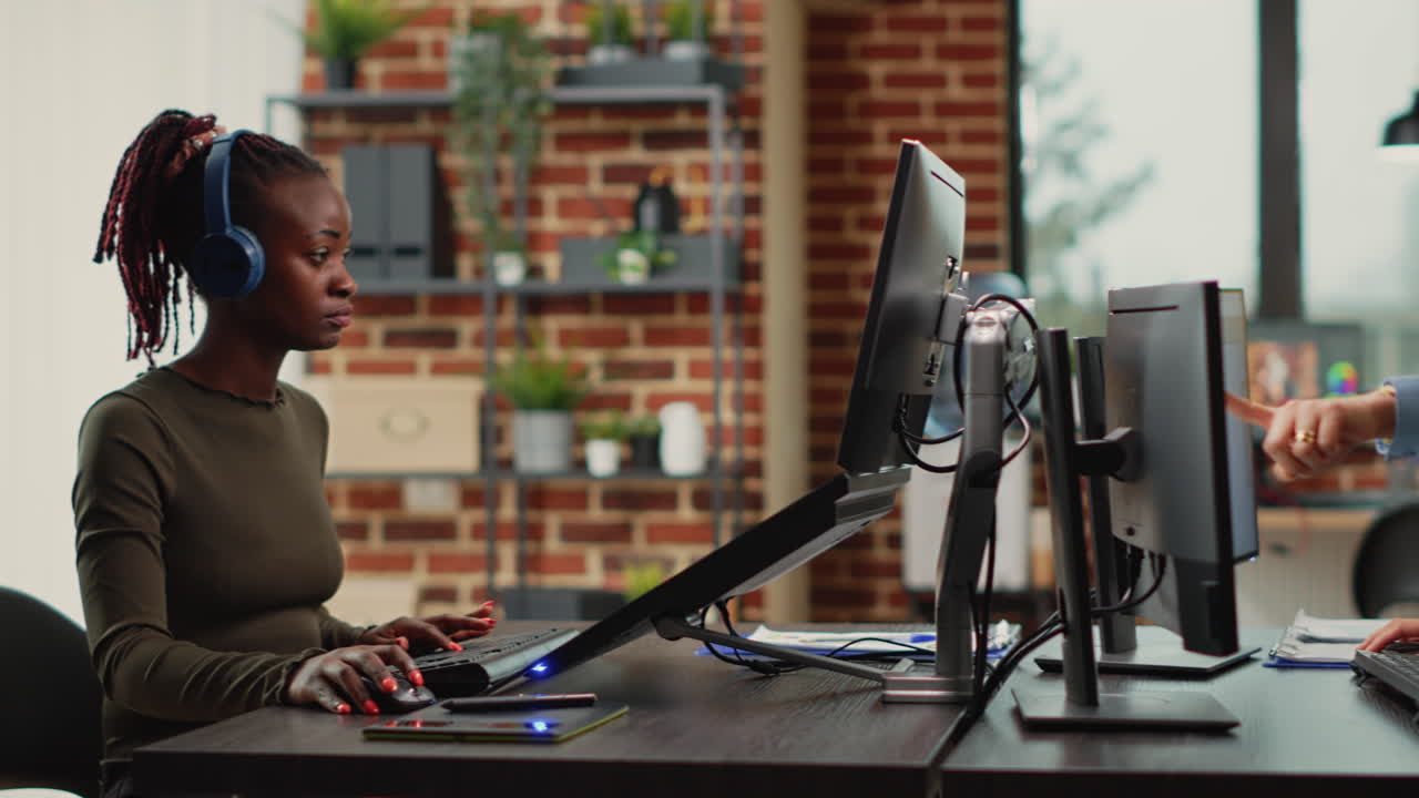 Female app developers working on software production with multiple displays