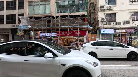 cars passing by a busy hong kong street