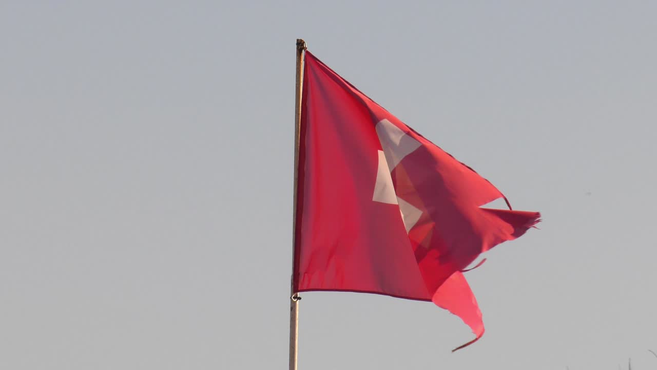 Bendera Swiss Tua Berkibar di Hari Berangin dengan Latar Langit Pucat