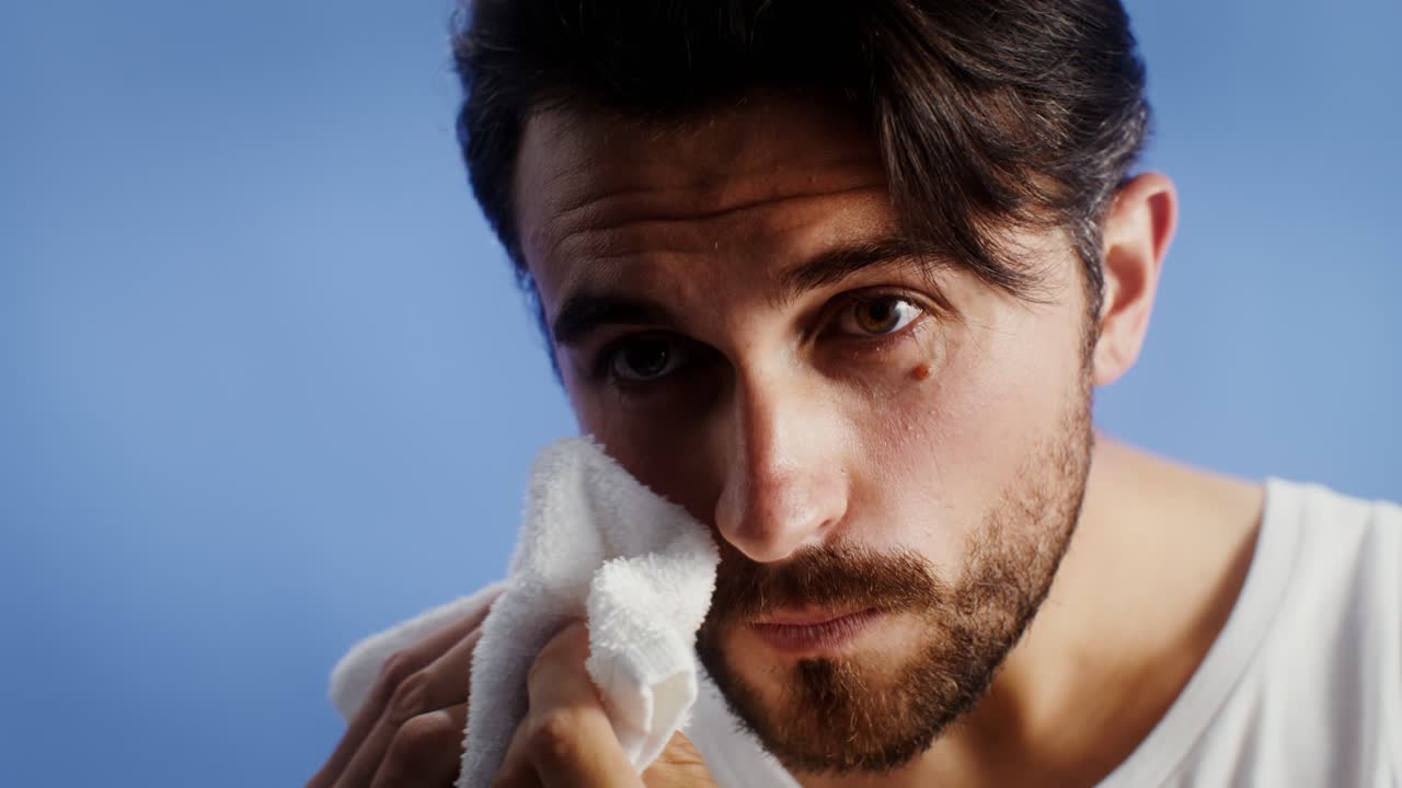 Man using a towel to clean his face