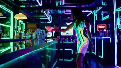 mujer elegante disfrutando de un cóctel en un club nocturno iluminado con neón