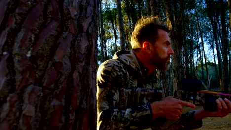 man aiming with compound bow in the forest 4k