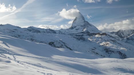 Toma-Panorámica-Lenta-Del-Paisaje-Montañoso-Cubierto-De-Nieve-Con-Matterhorn,-Alpes-Suizos-Famosa-Estación-De-Esquí-Del-Glaciar-Zermatt