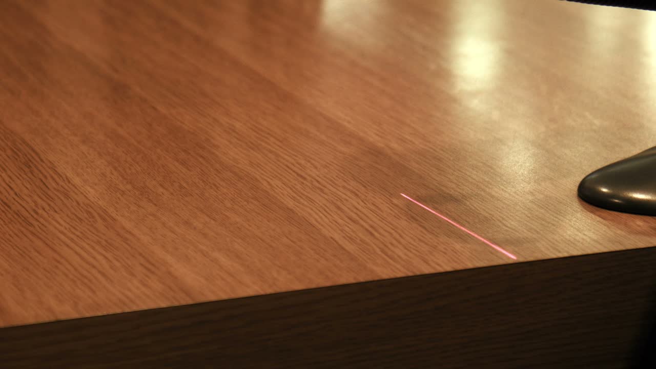 Close up of a wooden desk with a laser