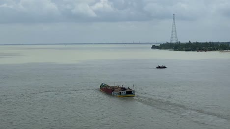 dolly disparó a lo largo de un puente con una barcaza de carga navegando por el río en sylhet