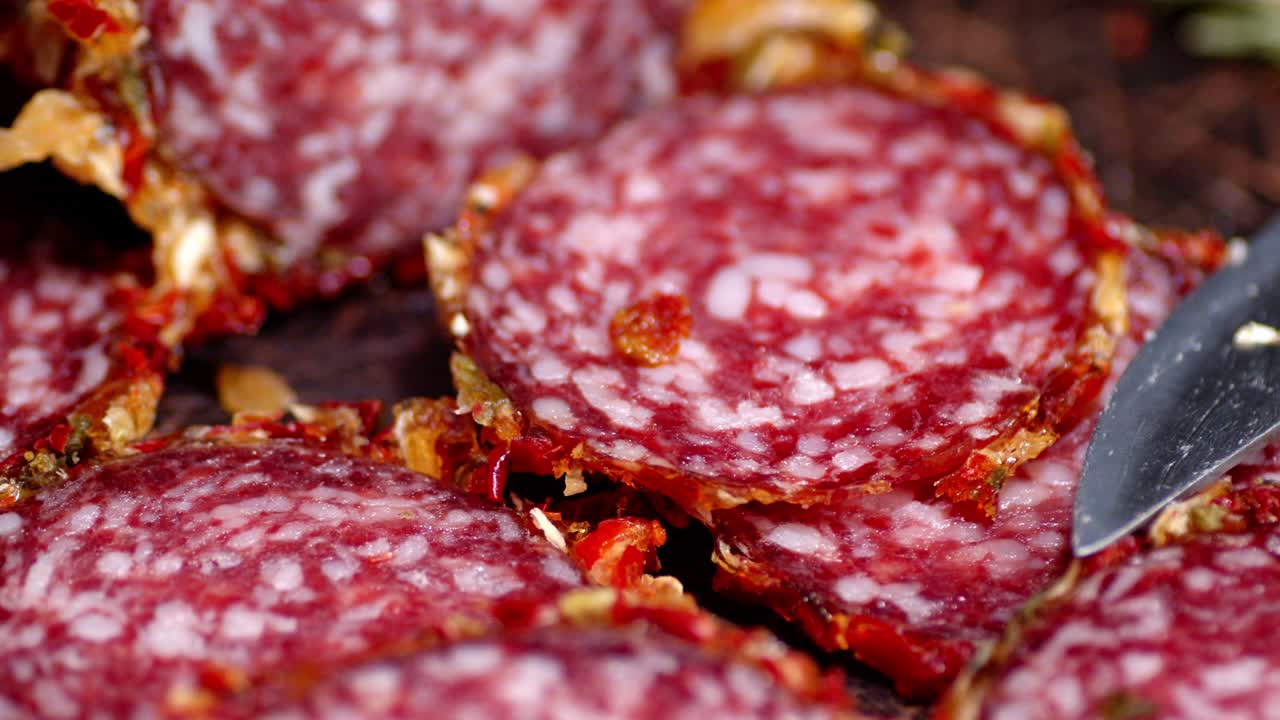 las piezas de salami giran lentamente sobre la mesa.