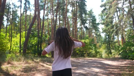 una chica caminando por un bosque.
