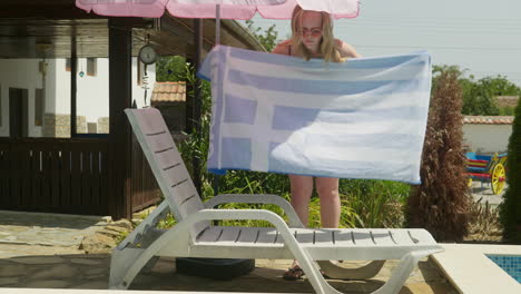 Girl-in-swimming-costume-lays-out-towel-on-sun-lounger-by-swimming-pool-to-sunbathe