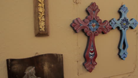 las coloridas cruces cristianas de recuerdo cuelgan de una pared naranja