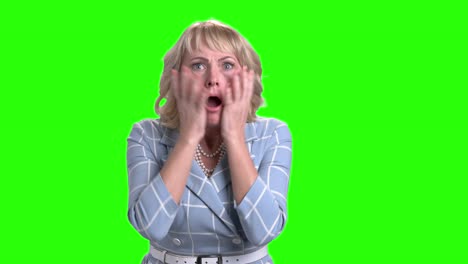 horrified mature woman on green screen.