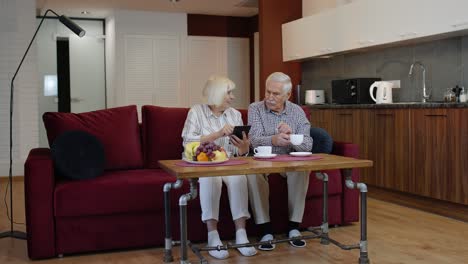 Pareja-De-Abuelos-Mayores-Hablando-Y-Usando-Una-Tableta-Digital-En-Casa.-Cierre-De-Emergencia-Por-Coronavirus