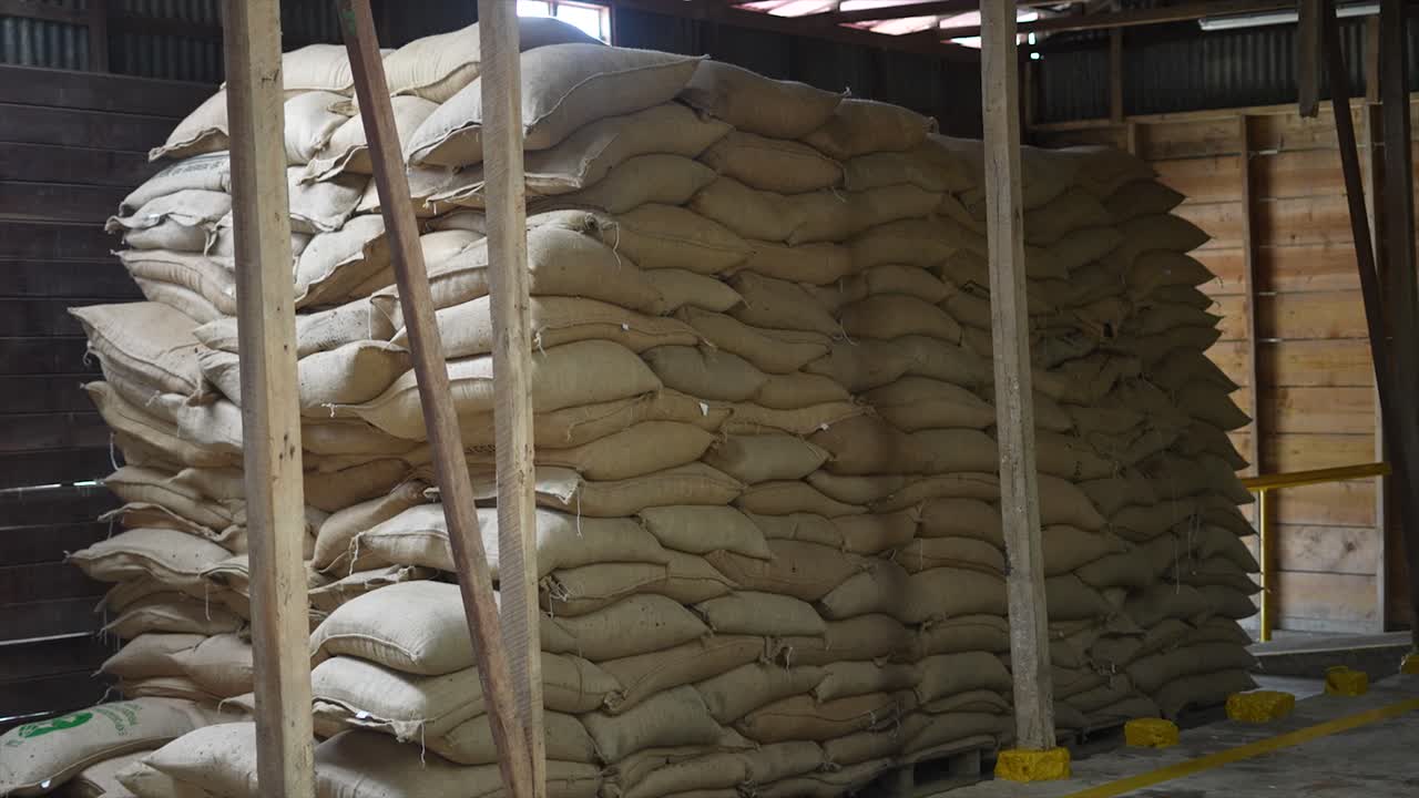 Large stacks of burlap sacks in a warehouse