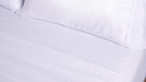 camera zooms slowly into crisp blanket edge and plush pillows