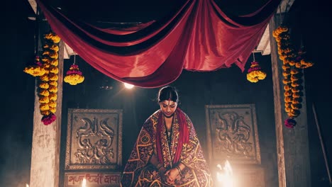 indian woman meditates peacefully in a mystical shrine, illuminated by the warm glow of candles and surrounded by vibrant floral decorations, creating a serene and spiritual atmosphere at night