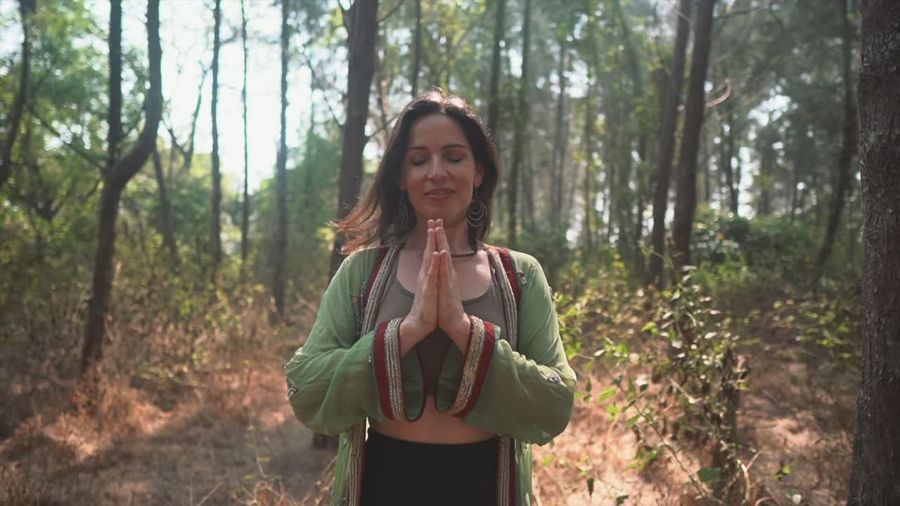 mujeres haciendo meditación en el bosque con el sol brillando a través de los árboles