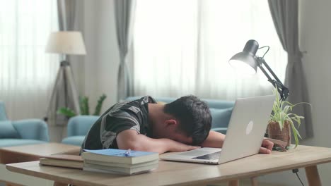 tired teen boy sleep on the table at home after doing home work