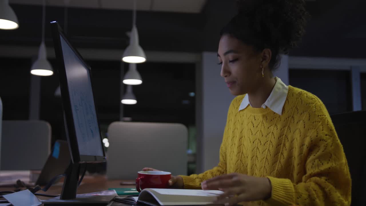 Businessman drinking coffee and working in a modern office by night