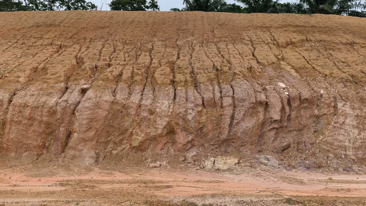A cut hill and slope are exposed for infrastructure construction. The barren surface lacks protection, increasing the risk of erosion, danger, and potential landslides