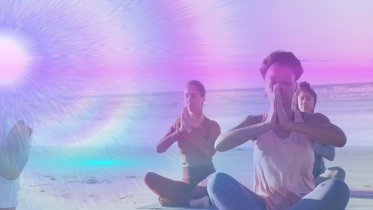 Three women practicing yoga on sandy beach, showcasing health theme with sun flare and purple rays