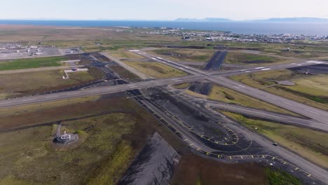 airport runway and taxiway on large open field, aerial