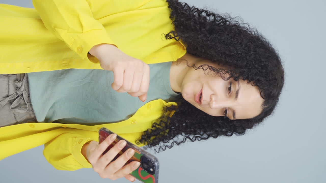 video vertical de la joven a la que le gusta la nueva aplicación. aplicación de teléfono.
