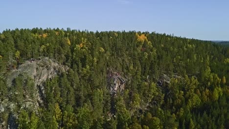 Mountain-in-a-forest,-national-park-of-Finland,-people-and-tourists-at-the-peak