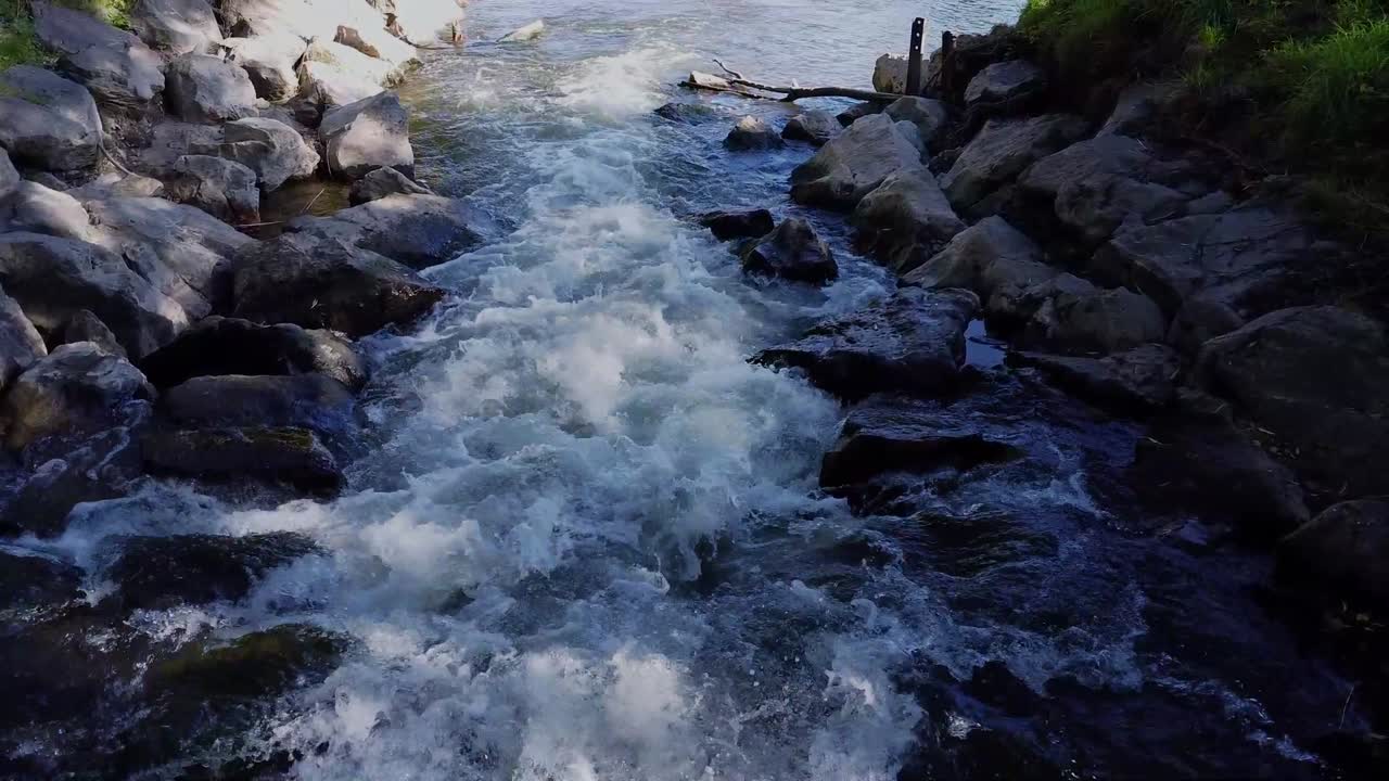 Rivier met stenen en bomen langs de kant.