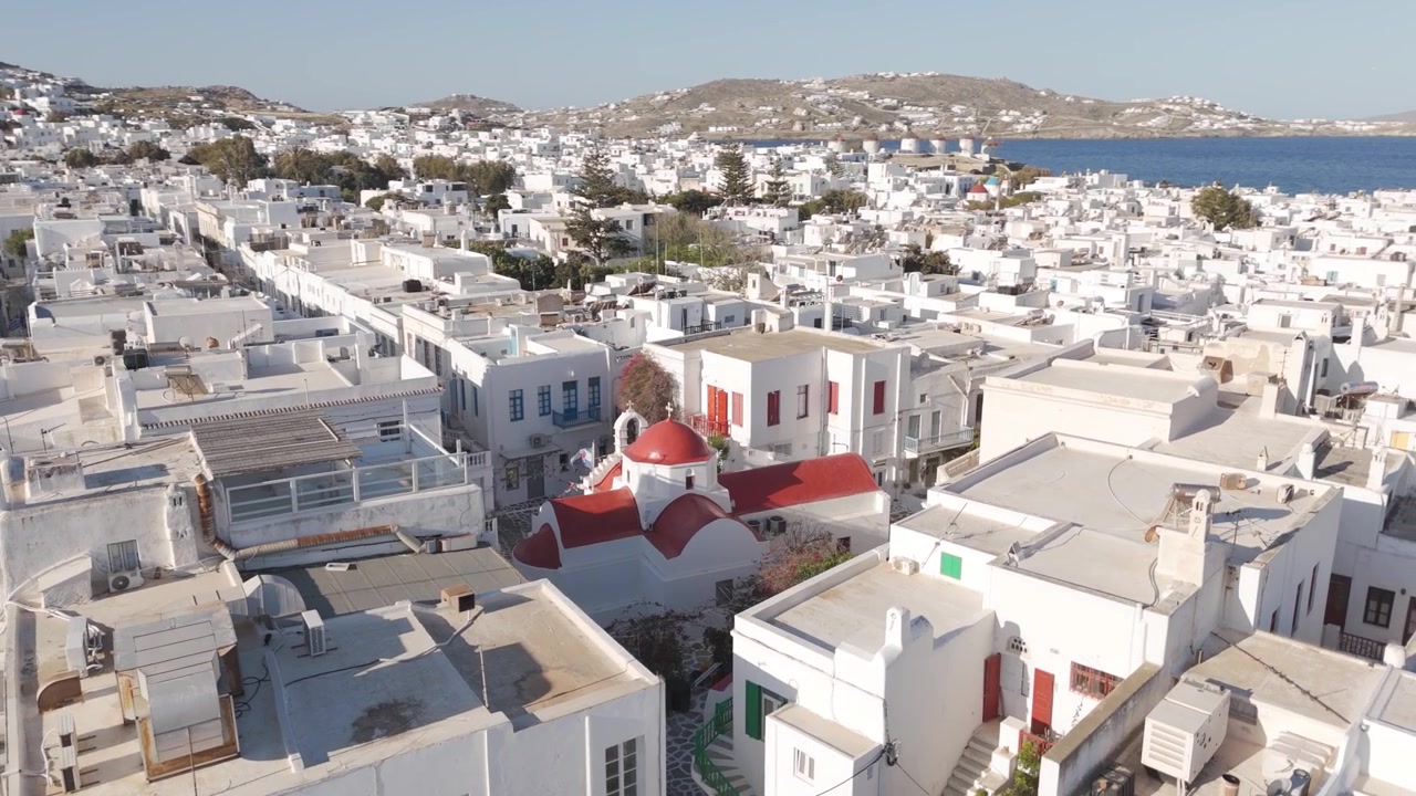 Tetti imbiancati a calce della città di Mykonos con la Chiesa di Agia Kyriaki dalla cupola rossa tra le case