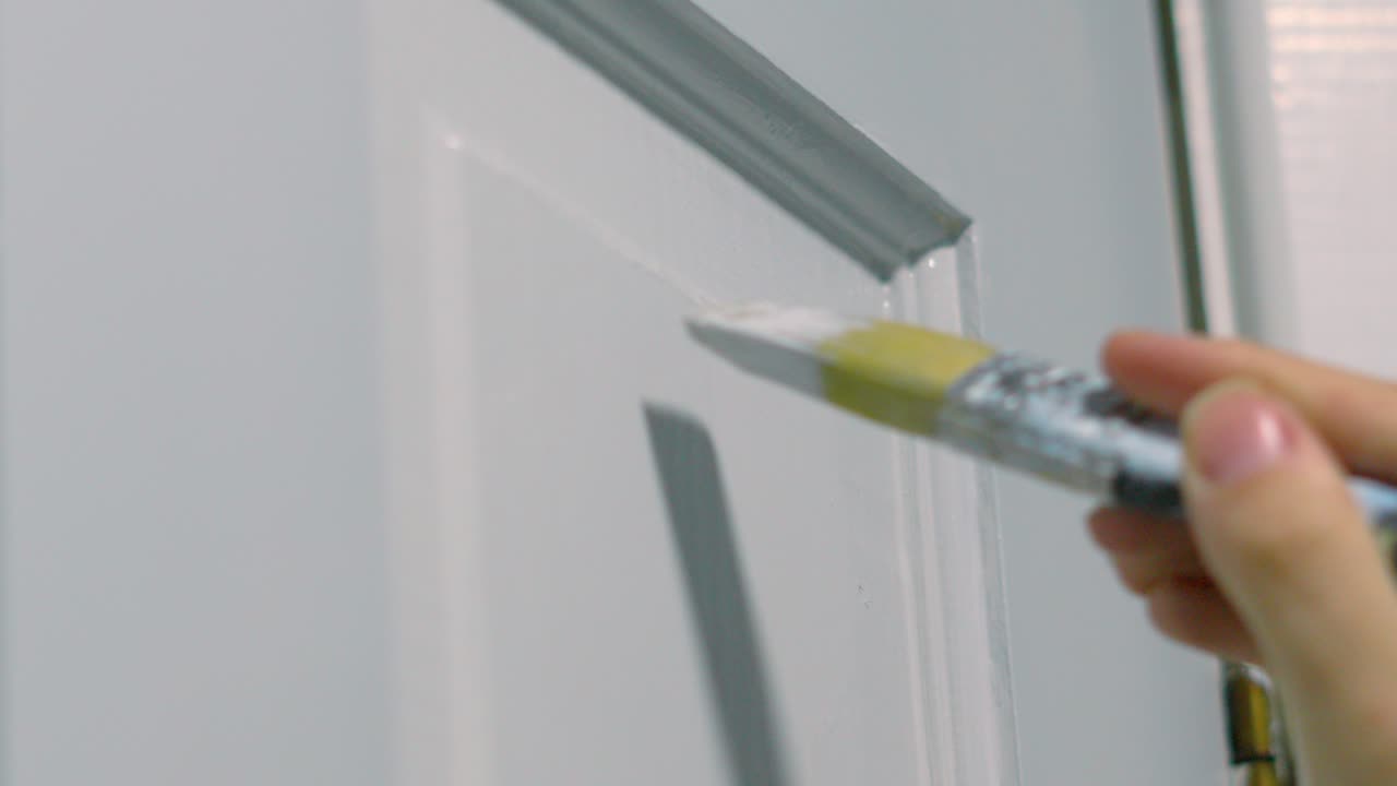 Female Hand Gently Using Paintbrush to Apply White Paint onto Wooden Door Doing DIY Work to Decorate Home House 4K