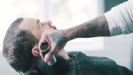 man getting a haircut and shave in a barbershop