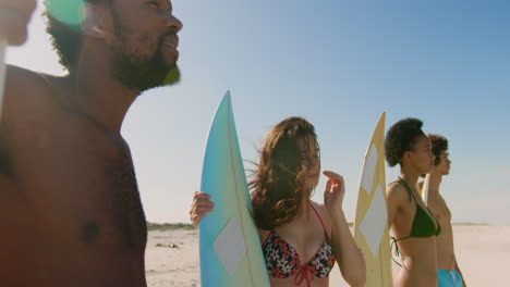 grupo de amigos felices de pie con la tabla de surf 4k