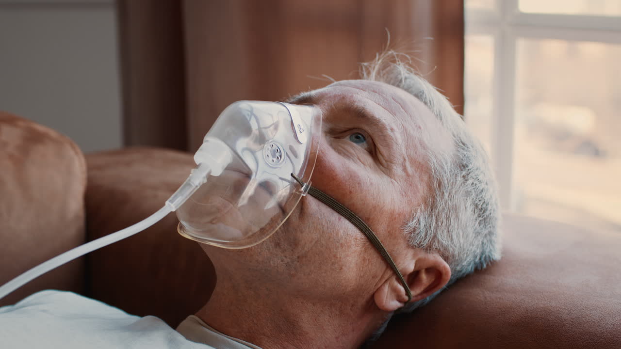 Elderly Man Receiving Respiratory Assistance at Home